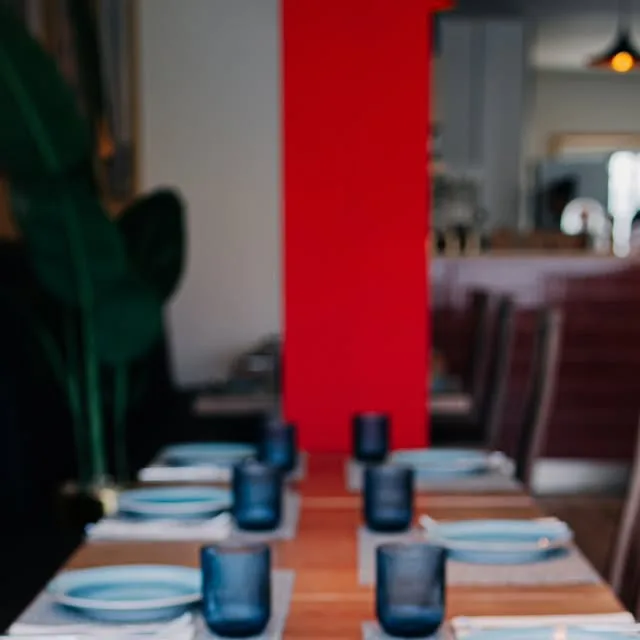A sala da Pizza da Vila, com mesas postas e a parede vermelha
